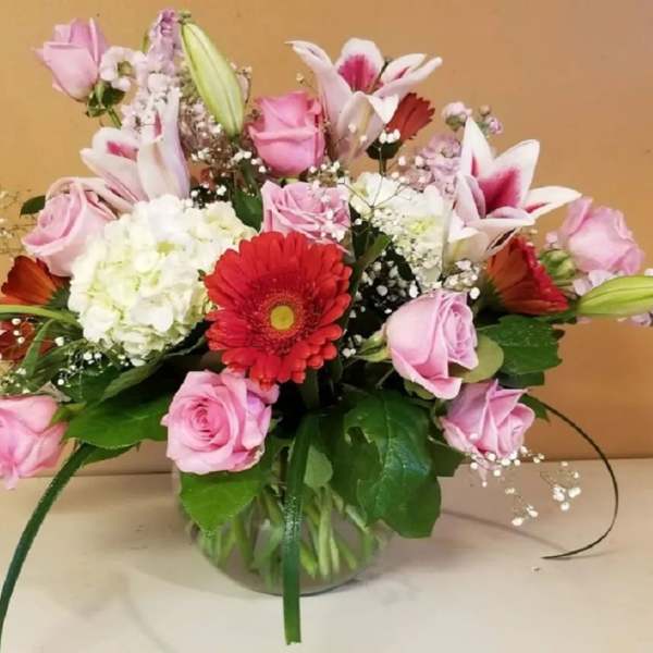Pink and white mixed flower arrangement in a glass vase