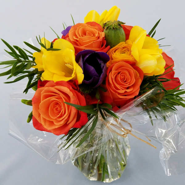 Bouquet of orange, yellow, red, and purple flowers wrapped in clear plastic