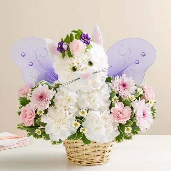 Flower basket arranged as a white cat with purple butterfly wings