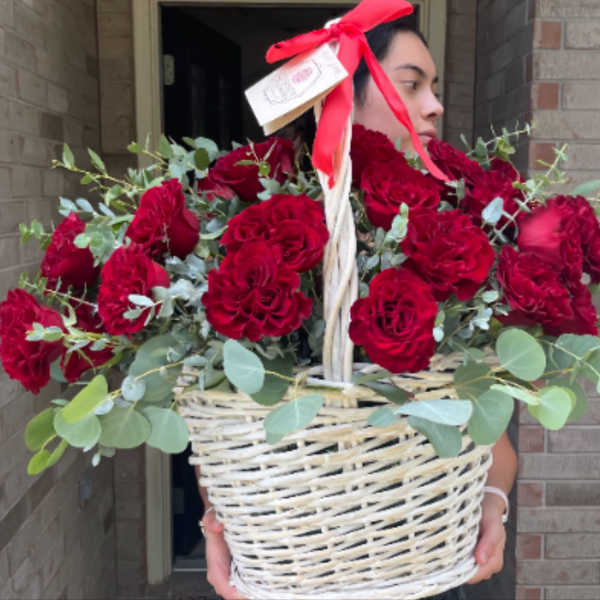 Basket of red roses with eucalyptus and a red ribbon