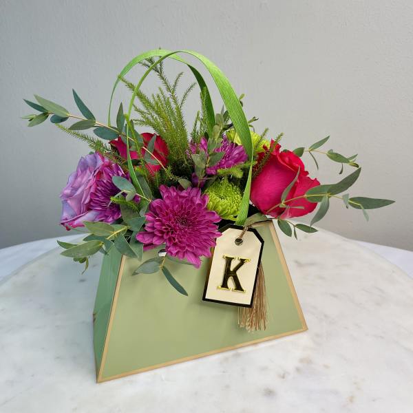 Mixed bouquet in a green gift box with a letter tag