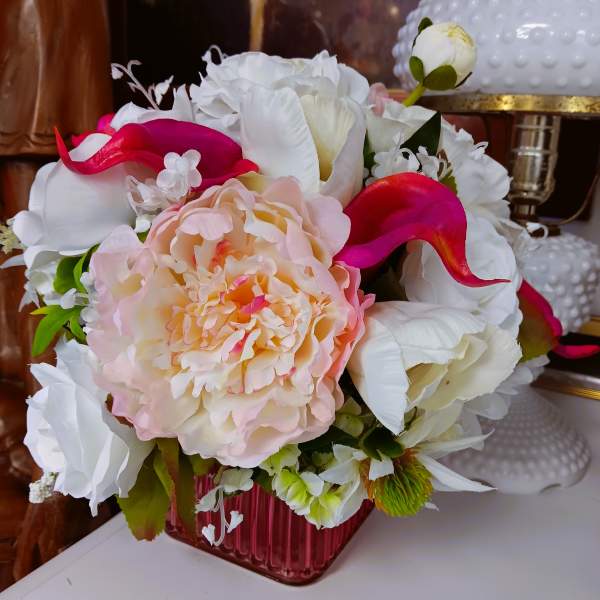 Bouquet of white and pink flowers in a pink glass vase