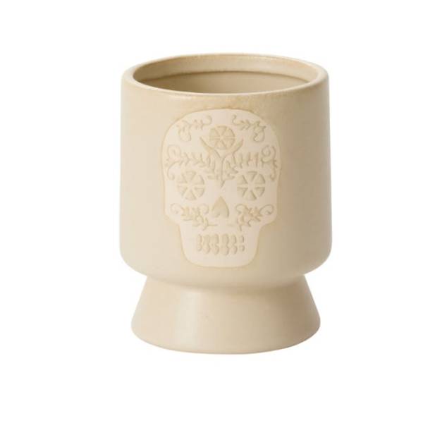 Cream ceramic candle holder with a skull relief design