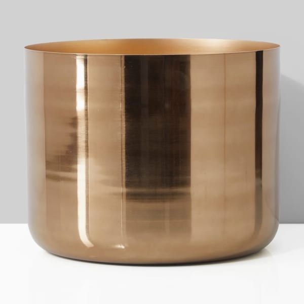 Gold metallic cylindrical vase on a plain background