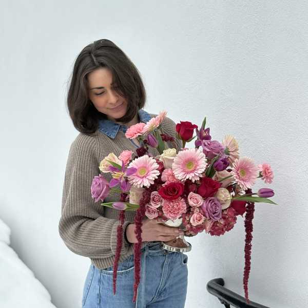 Woman holding a large pink and purple bouquet