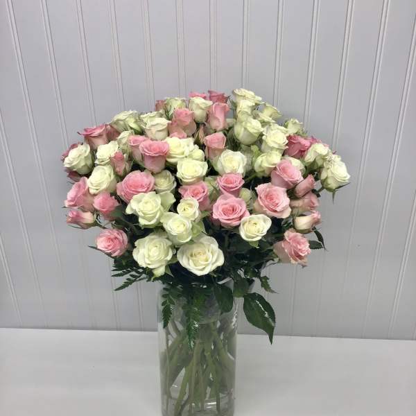 Bouquet of pink and white roses in a clear glass vase