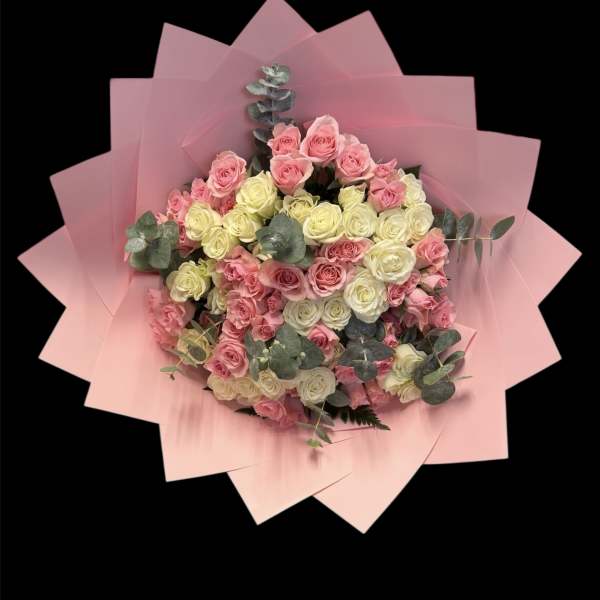 Bouquet of pink and cream roses wrapped in pink paper