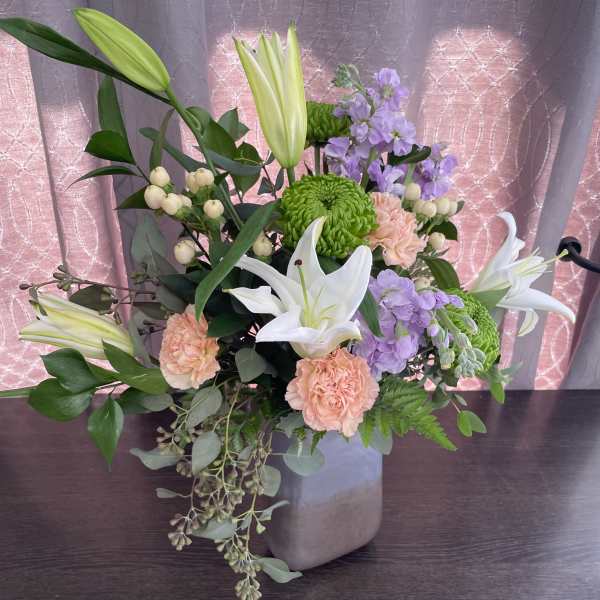 Mixed bouquet with white lilies, green chrysanthemums, and peach carnations in a vase