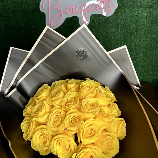 Bouquet of yellow roses wrapped in black paper