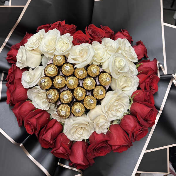Heart-shaped bouquet of red and white roses with gold-wrapped chocolates in the center