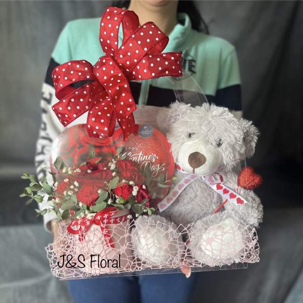 Gift basket with red roses, a teddy bear, and a heart balloon
