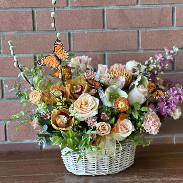 Mixed floral basket with roses, orchids, and butterfly picks