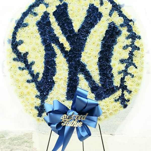 Circular floral tribute with a blue-and-white Yankees logo and ribbon