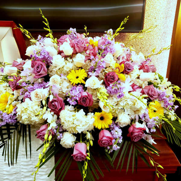 Large floral arrangement with pink and white roses, hydrangeas, and yellow daisies