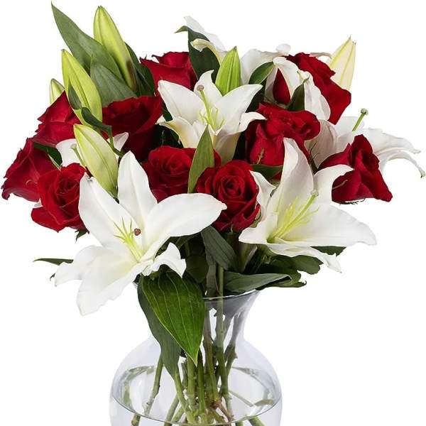 Red roses and white lilies arranged in a clear glass vase