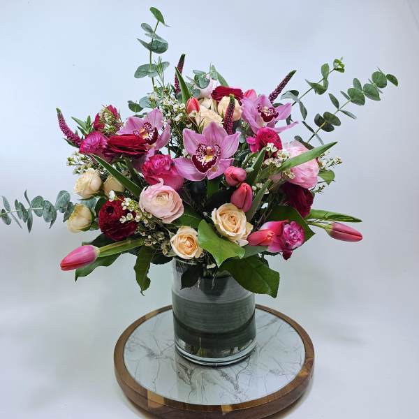 Pink and cream floral arrangement in a glass vase