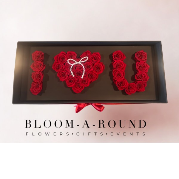 Red roses arranged as "I ♥ U" in a black gift box