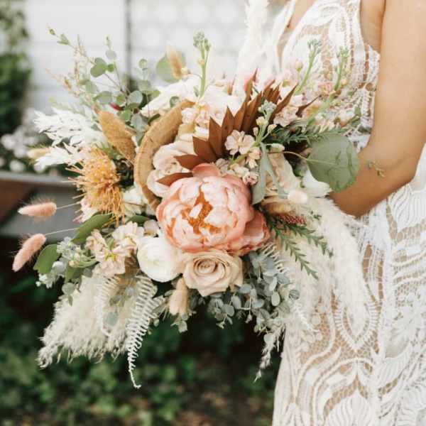 Bride holding a large peach and white bouquet