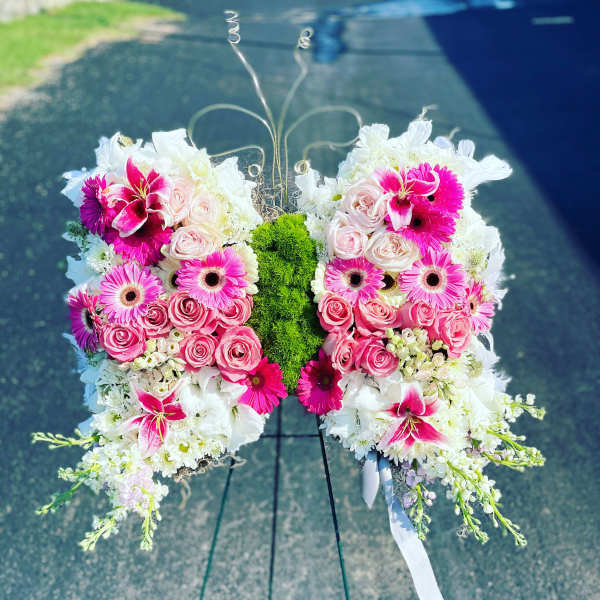 Butterfly-shaped floral arrangement with pink roses and white lilies