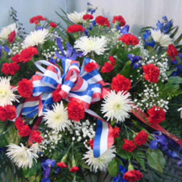 Red, white, and blue funeral spray with ribbon bow