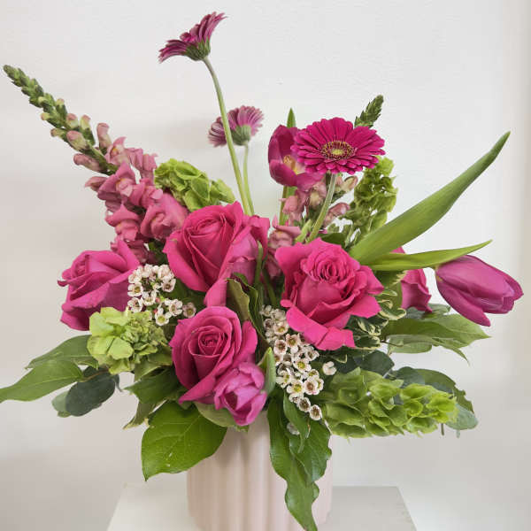 Pink roses and gerbera daisies in a pale vase