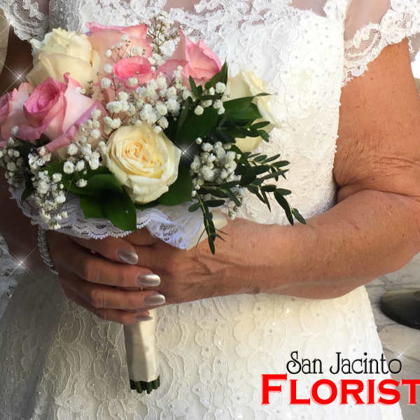 Bride holding a bouquet of pink and white roses