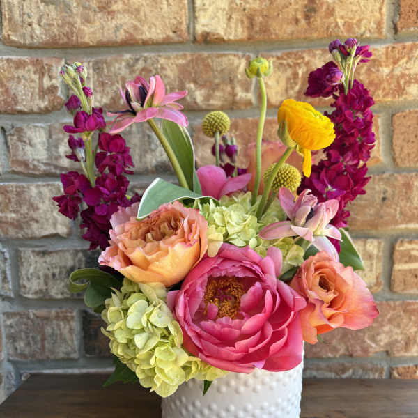 Bright mixed bouquet in a white textured vase