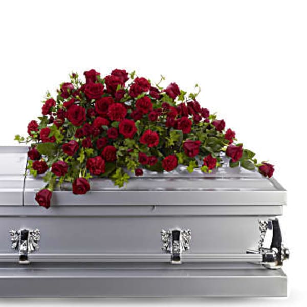 Red rose spray on top of a silver casket