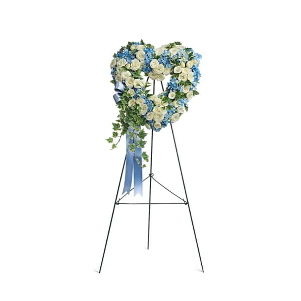 Heart-shaped blue and white standing wreath with roses and hydrangeas on a tall metal easel