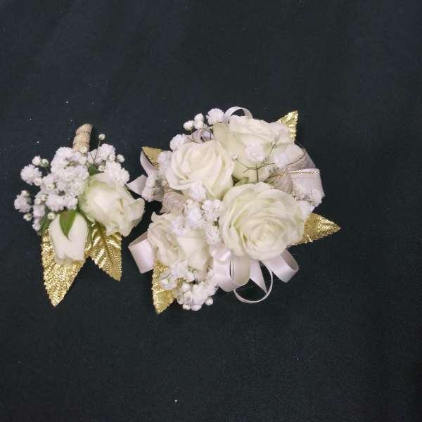 White rose corsages with baby's breath and gold accents