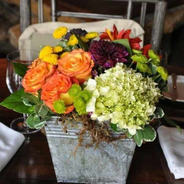 Mixed bouquet in a square metal container with orange roses and hydrangea