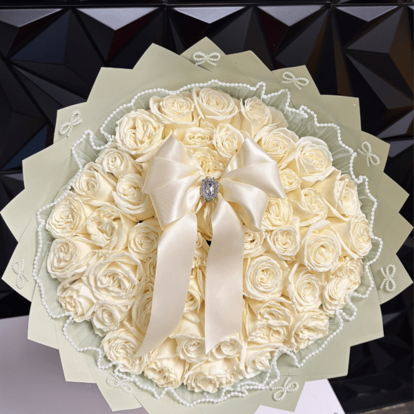 Cream rose bouquet with a satin bow and pearl trim