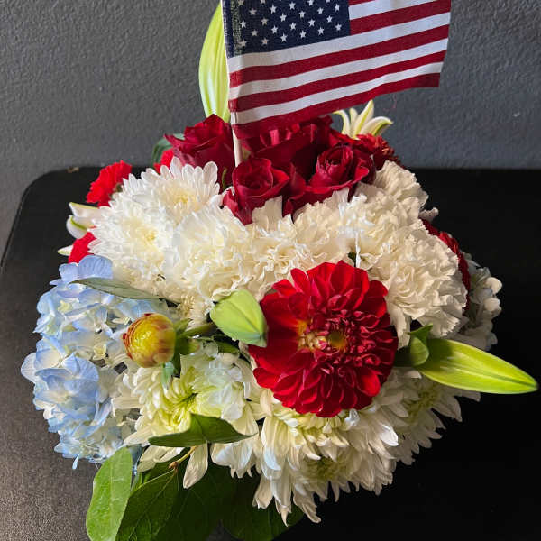 Red, white, and blue flower arrangement with an American flag
