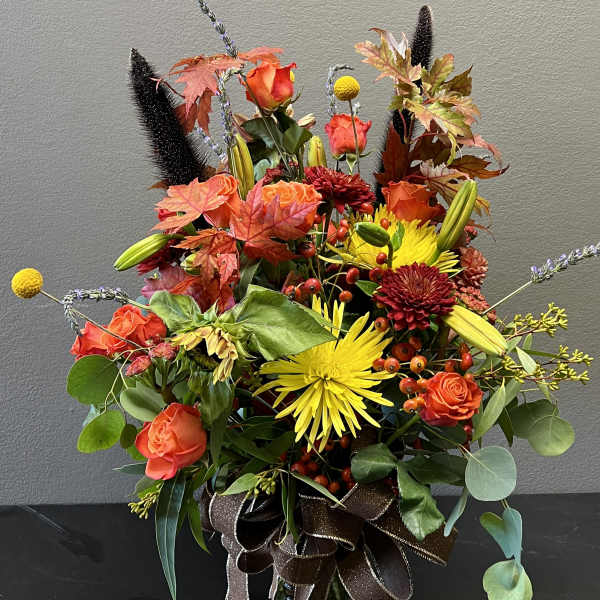 Autumn bouquet of orange and yellow flowers in a glass vase
