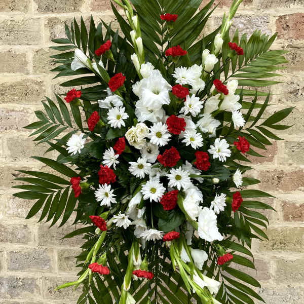Standing floral spray with red and white flowers and palm fronds