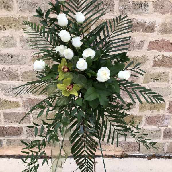 Tall floral standing spray with white roses and tropical greenery