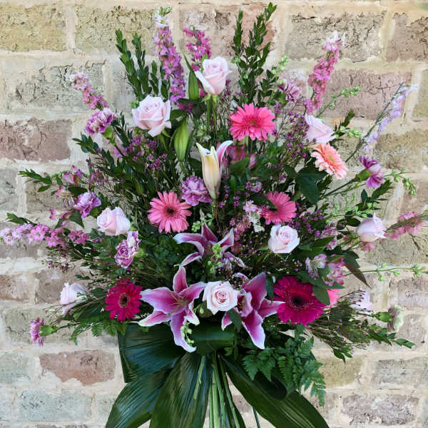 Large pink and white floral standing spray on an easel