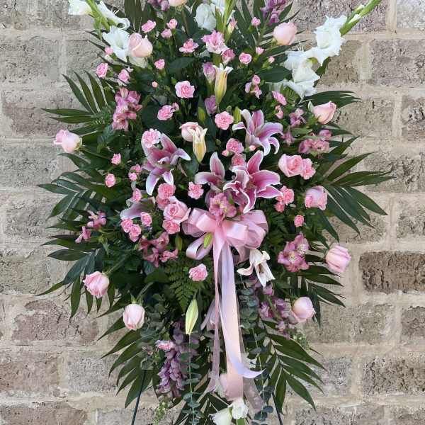 Tall pink and white floral standing spray with lilies and roses