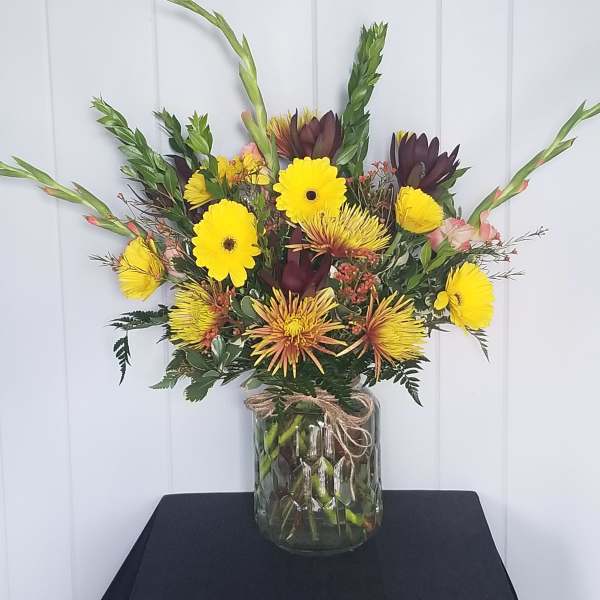 Yellow and burgundy mixed bouquet in a glass vase