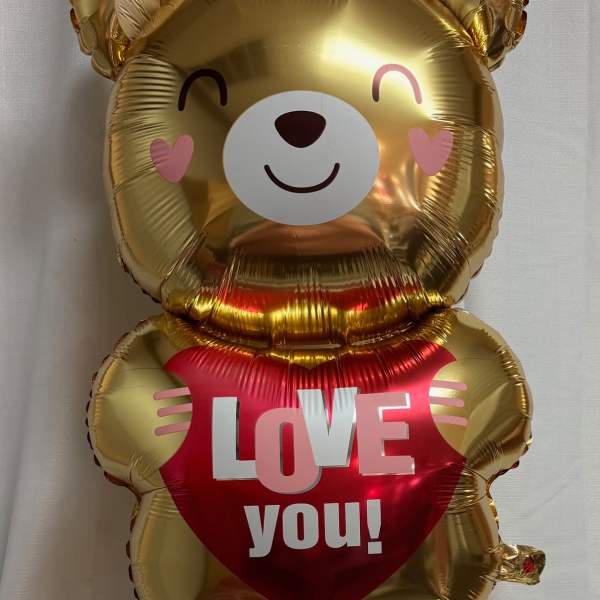 Gold teddy bear balloon holding a red heart that says "LOVE you!"