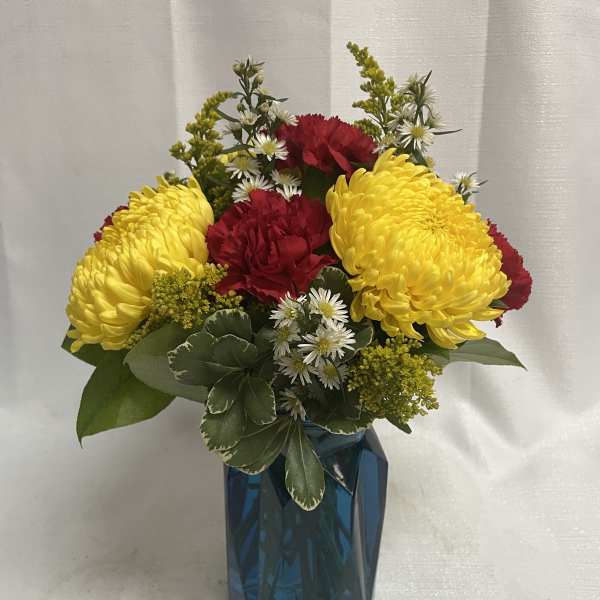 Yellow and red flowers arranged in a blue vase