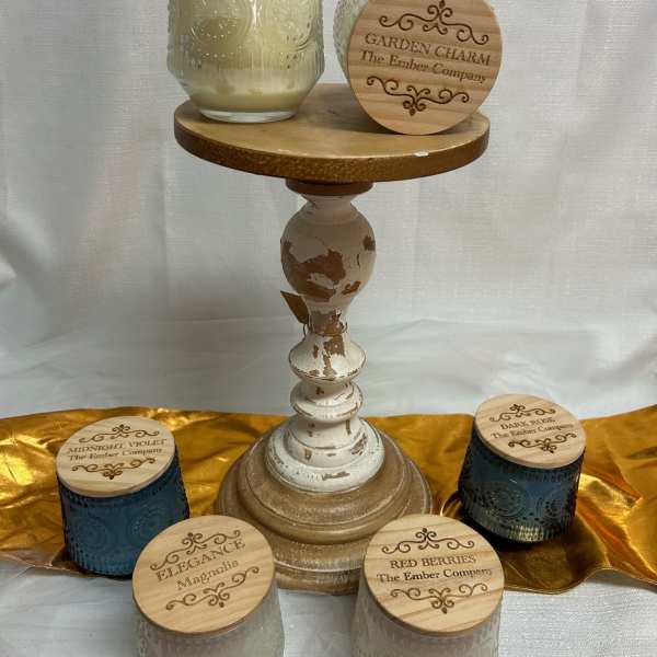 Assorted scented candles in glass jars on a decorative pedestal stand