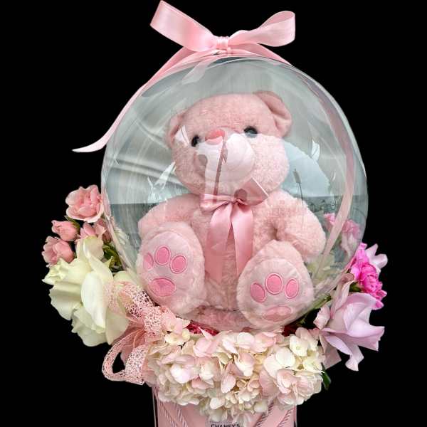 Pink teddy bear in a clear balloon dome with pastel flowers and a pink box