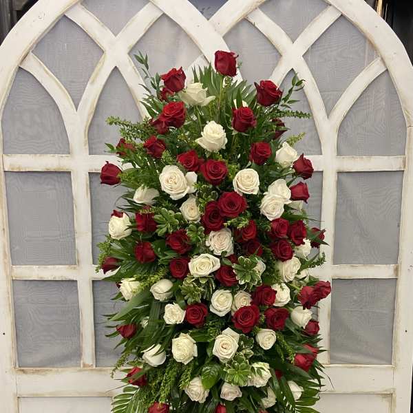 Tall standing arrangement of red and white roses on an easel