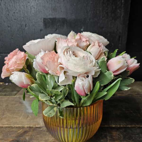 Pink and white flowers arranged in an amber glass vase