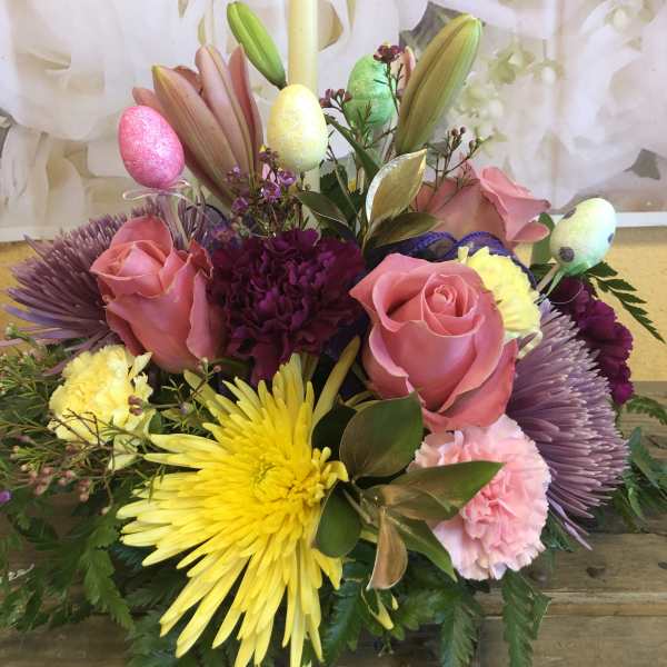 Pink roses and yellow chrysanthemums arranged with pastel Easter eggs