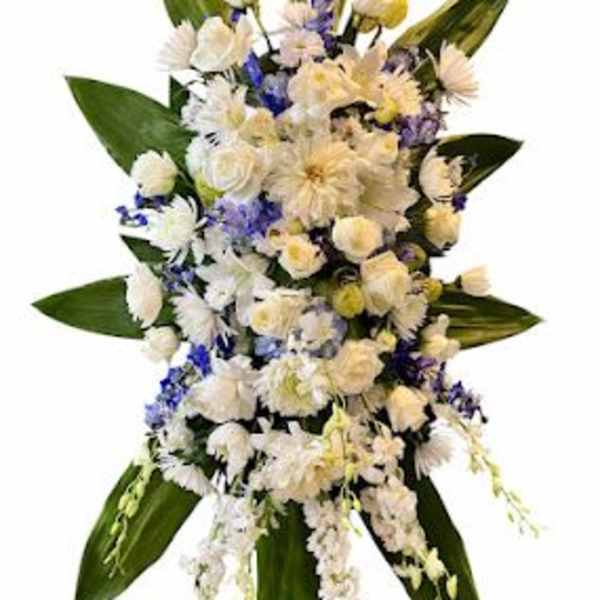 White and pale yellow floral spray with blue accents and large green leaves