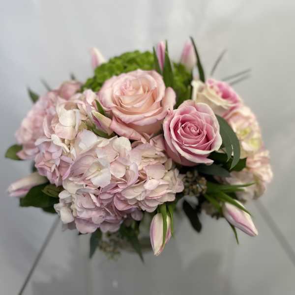 Pink roses and pale hydrangeas in a hand-tied bouquet