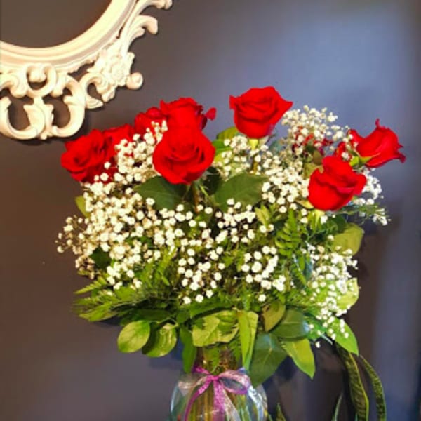Red roses and baby's breath in a clear glass vase