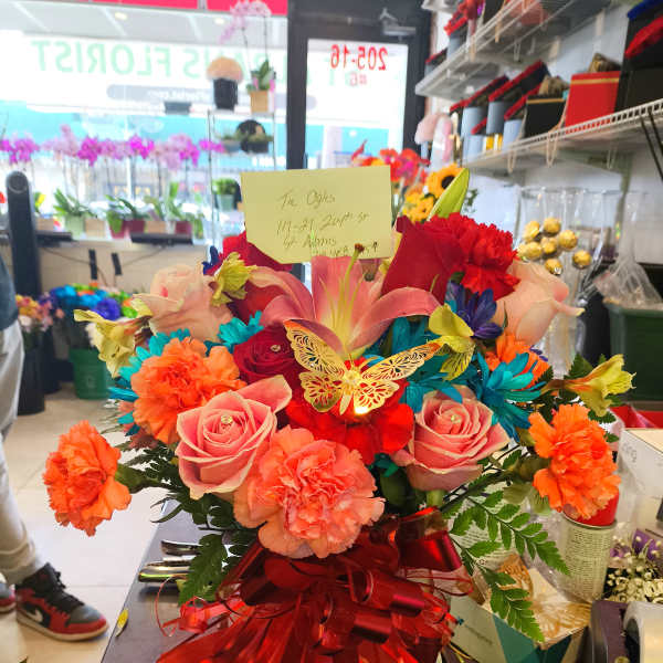 Bright mixed bouquet with roses, lilies, and carnations in a gift box